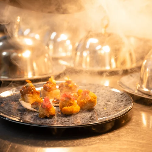 Reppert, Ihr Hotel in Hinterzarten im Schwarzwald Gourmet-Häppchen auf Teller mit Dunst und Glaskuppeln im Hintergrund