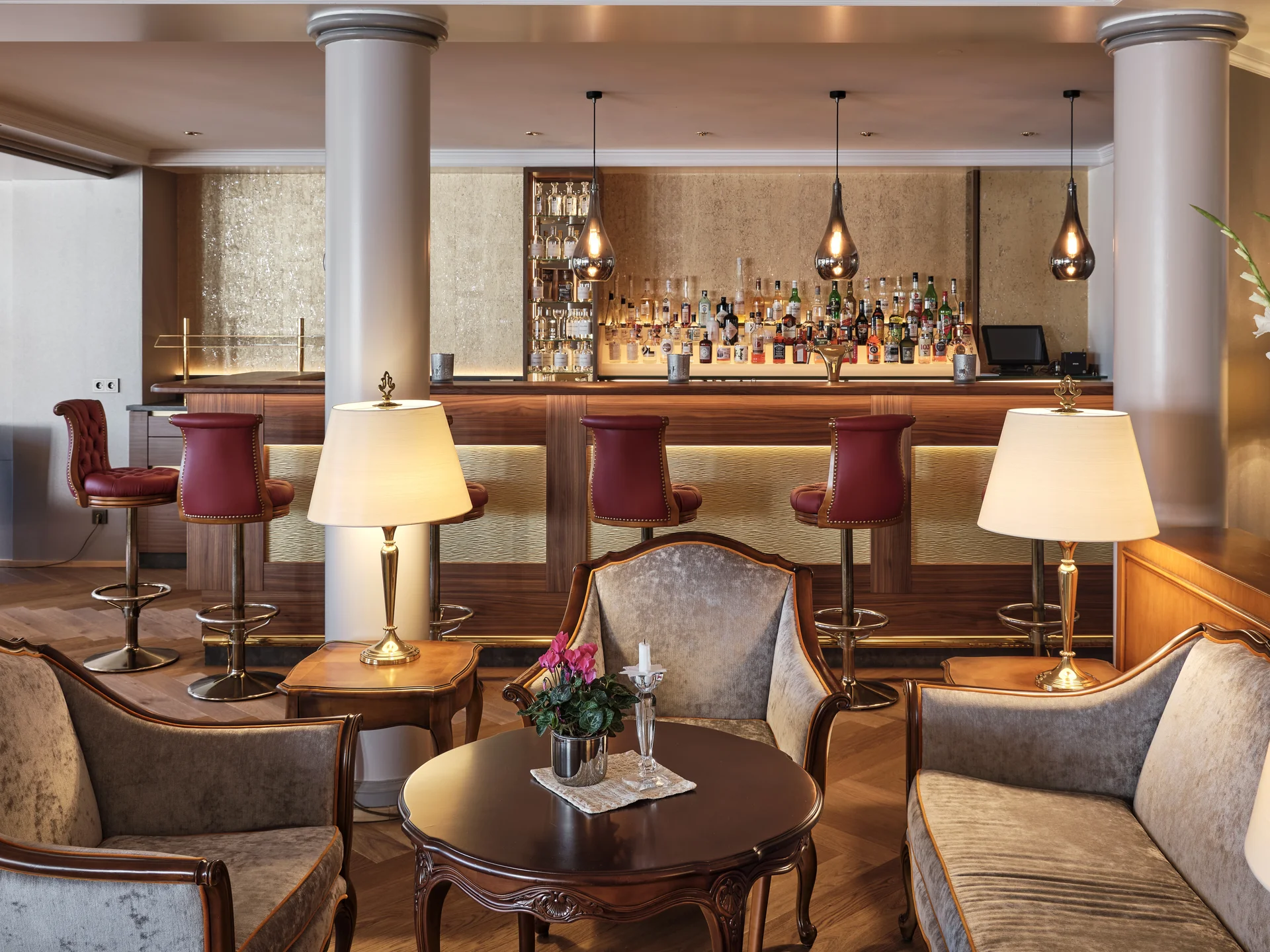 Reppert, Ihr Hotel in Hinterzarten im Schwarzwald Elegante Hotelbar mit Polstersesseln, Holztisch und beleuchtetem Barbereich