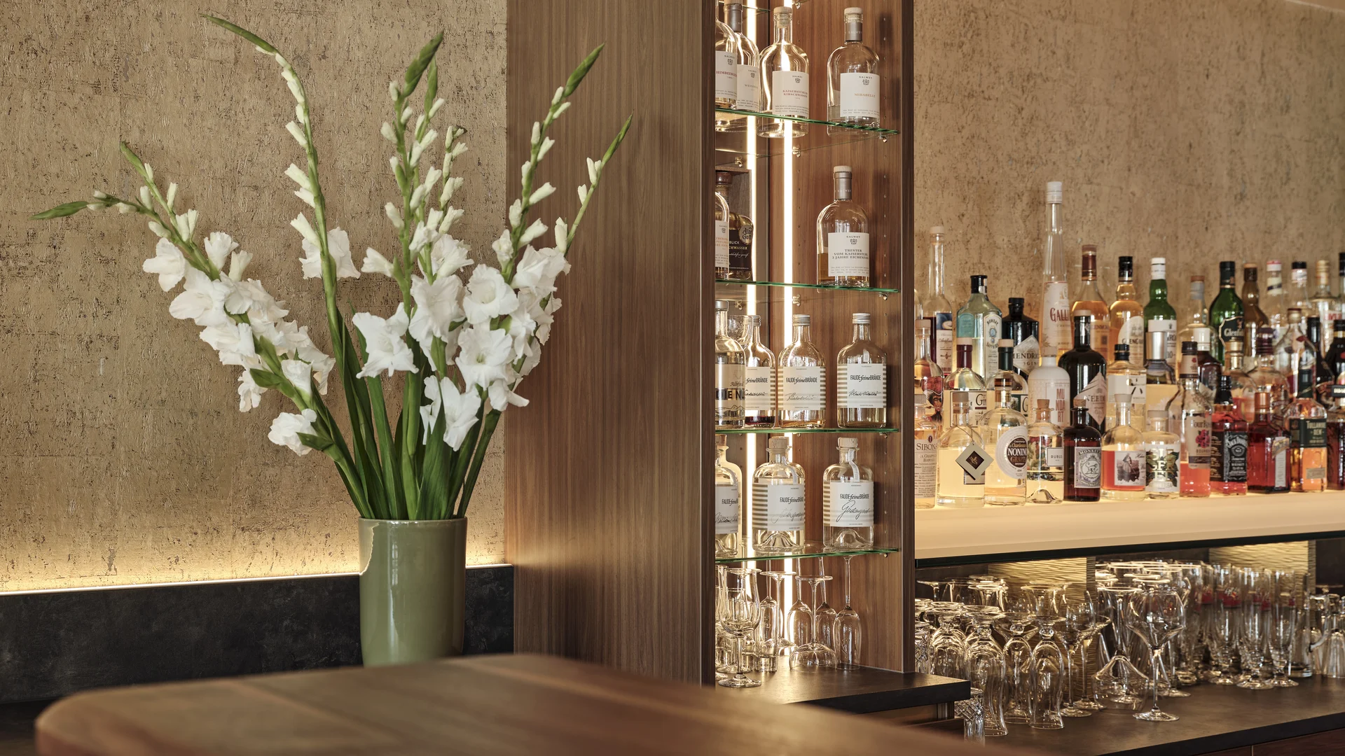 Reppert, Ihr Hotel in Hinterzarten im Schwarzwald Bar mit Spirituosen, Gläsern und weißer Blumendekoration