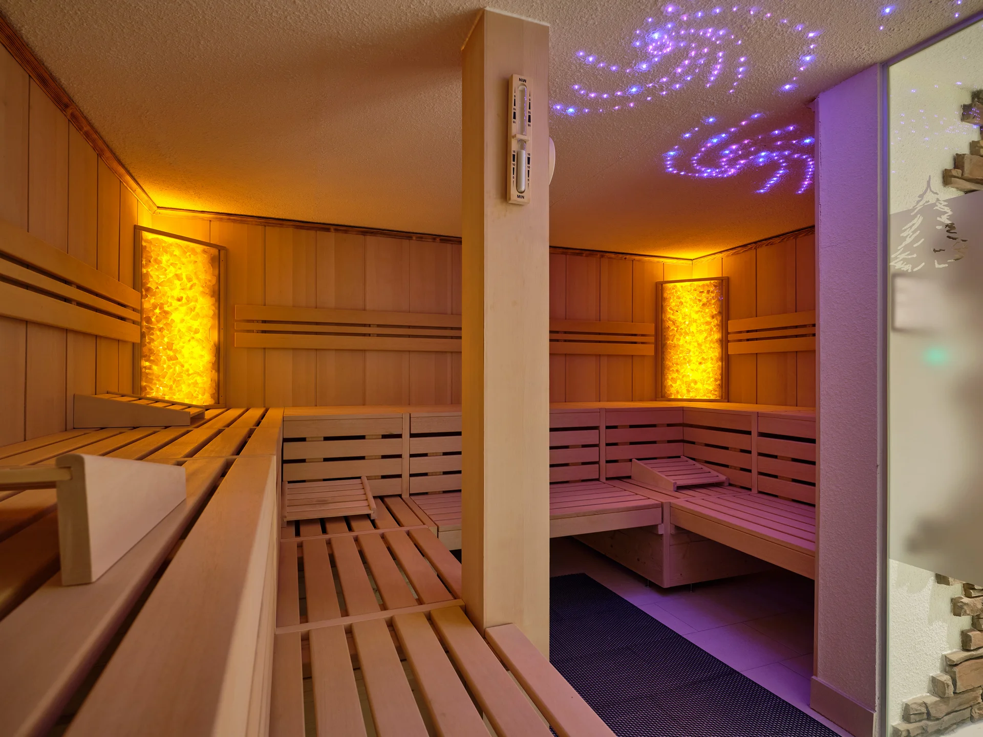 Reppert, Ihr Hotel in Hinterzarten im Schwarzwald Innenraum einer Sauna mit Holzsitzbänken und beleuchteten Wänden