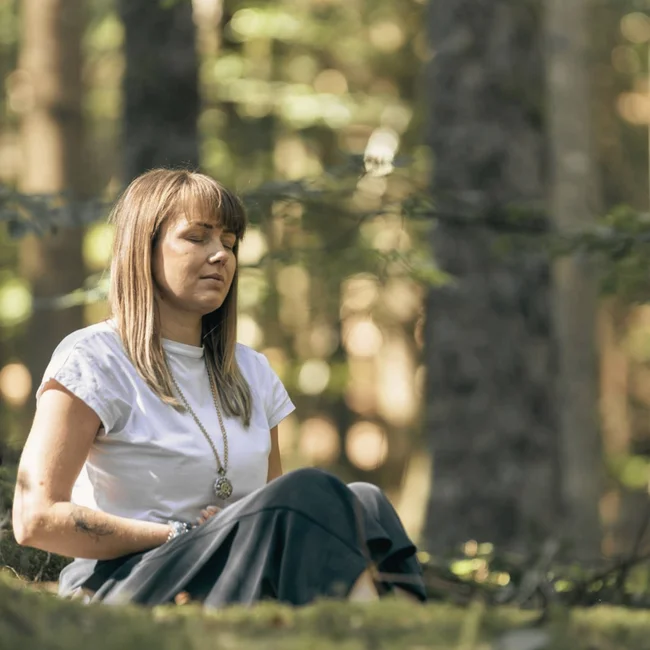 Your spa hotel in the Black Forest | Hotel Reppert Woman meditating peacefully in the forest with closed eyes